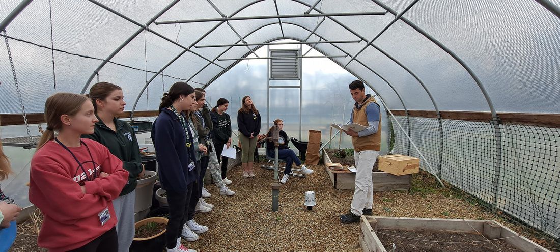 Students touring a greenhouse with an instructor
