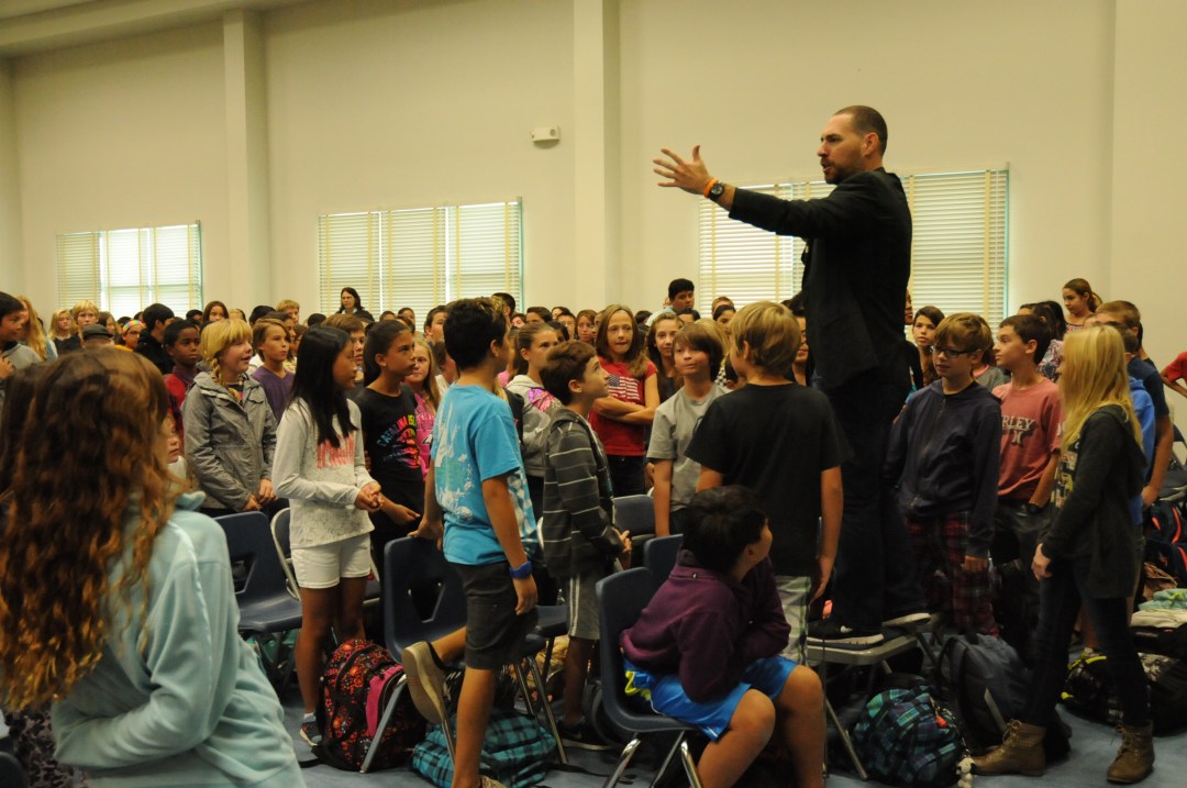 A speaker addressing students at a school assembly
