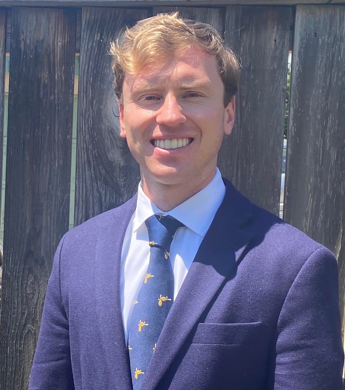 William P. Bednarz, in a navy suit and patterned tie, photographed outdoors